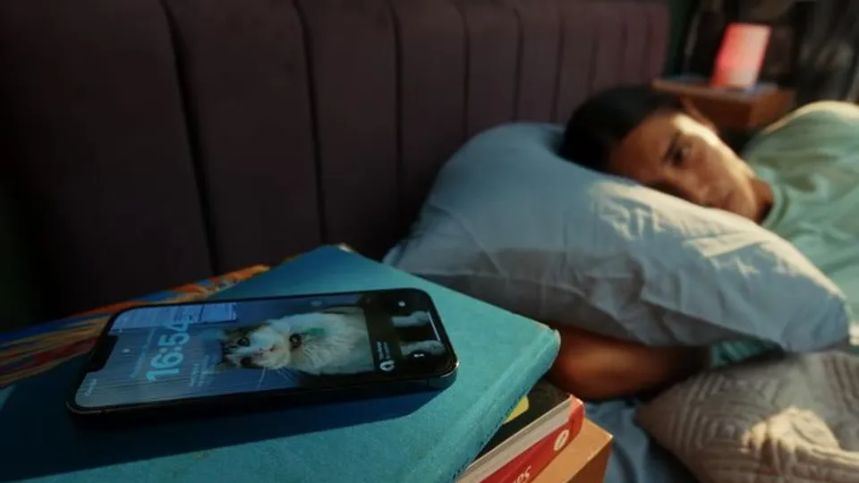 In bed, staring at the phone on the nightstand