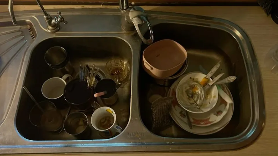 Sink piled with dirty dishes