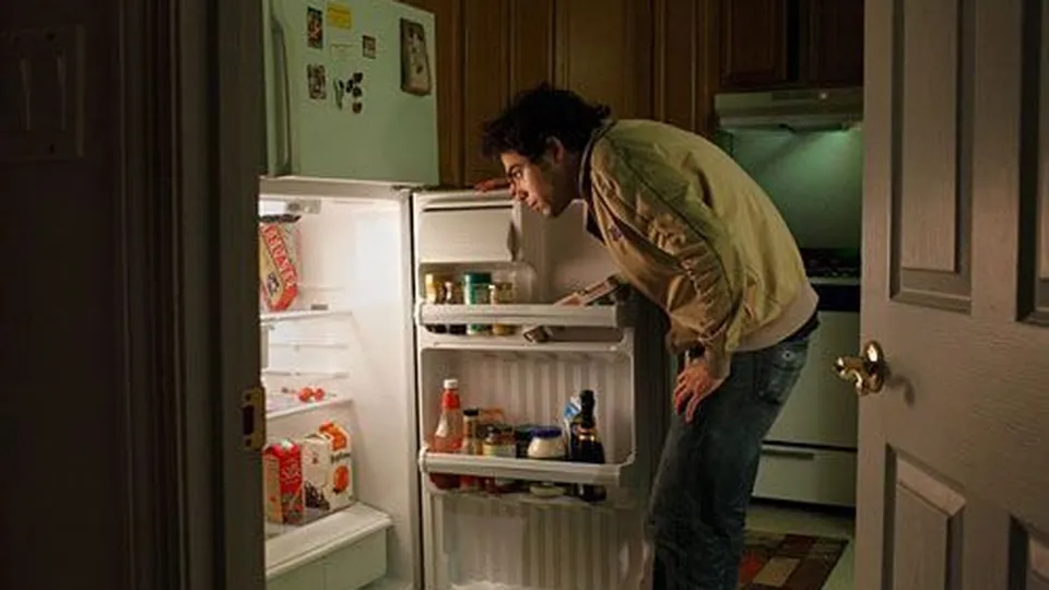 Leaning into an open fridge
