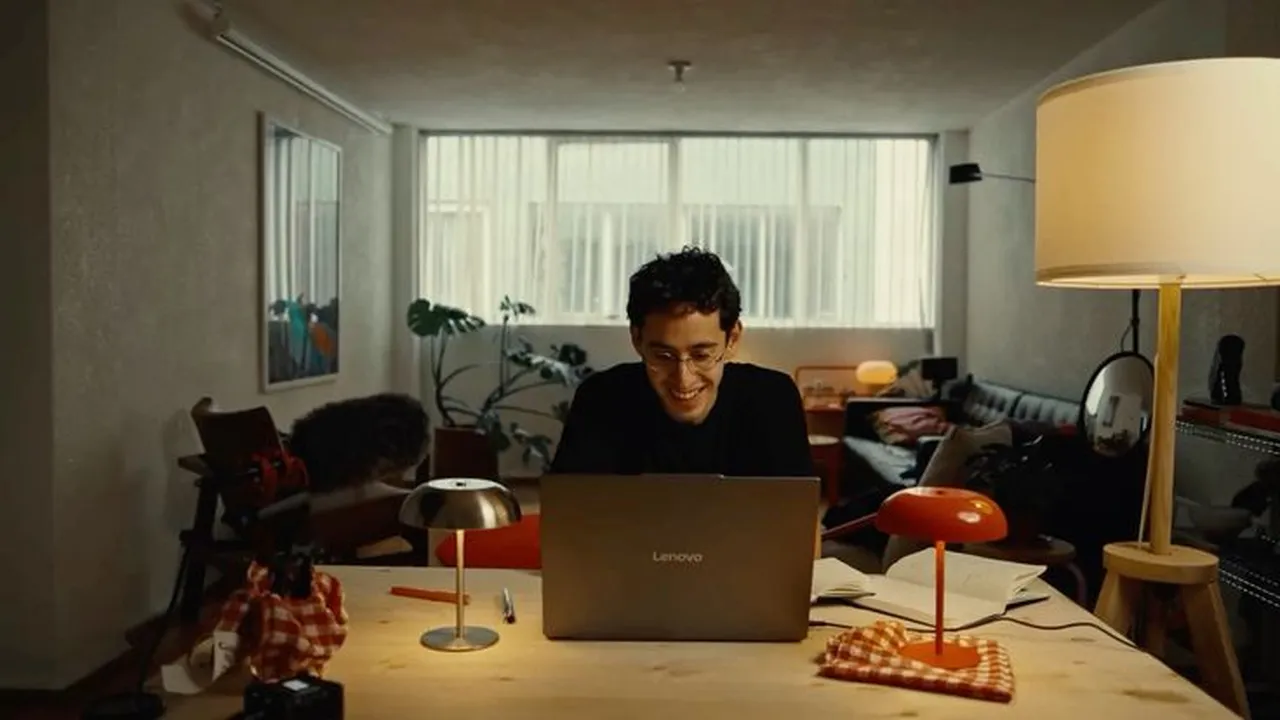 Smiling at the laptop in a warm, lit room